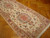 Cantaloupe guard borders frame delicate vine scrolls on this hand-knotted Persian hallway runner