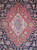 Close-up of ivory and sky blue medallion core on red ground surrounded by navy florals