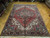 Angled view of warm brick red field, ivory spandrels and deep navy main border