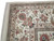 Corner close-up showing tortilla brown guard stripes, burgundy rosettes and hand-tied ivory fringe detail