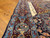 Close view of burgundy and light blue border with bird motifs beside ivory calligraphy panel