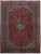 Red field Persian Kashan rug showing navy lobed medallion, ivory spandrels and floral borders