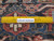 Back of the rug beside a ruler showing hand-knotted wool knots per square inch density