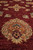 Macro angle of a salmon palmette medallion showing hand-knotted wool pile and soft luster
