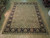 9'1" x 12' Chobi Oriental rug photographed on light wood showroom floor, green field