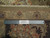 Back of rug with ruler and Authentic Handmade label showing hand-knotted wool weave