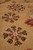 Low angle macro of brown and black outlined snowflake rosettes on dense hand-knotted wool pile