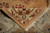 Folded corner revealing even knotting, cotton foundation and the ivory fringe of this square rug
