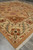 8x8 square Indian Oushak area rug photographed from the corner with wide floral ivory border