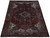 8'2" x 11'6" Persian Heriz rug photographed at an angle showing red field and ivory corners