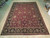 9'10" x 14' Indian Agra rug displayed flat on wood floor, all-over floral design visible