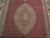 Close-up of ivory scalloped medallion framed by tiny herati fish motifs on red ground