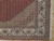 Corner detail showing ivory palmette border, green vine scrolls and cotton fringe on hardwood