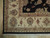 Ivory main border with camel guard stripes meeting black field, corner of large India rug