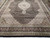 Wide corner view showing the black main border with palmettes, rosettes and ivory vine scrollwork