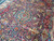 Close detail of turquoise center medallion surrounded by pink blossoms, birds and woven vases