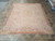 Blush Aubusson flat weave rug displayed on stone floor showing salmon border and cream floral field