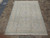 6'6" x 9'6" Persian Tabriz rug displayed flat on tile showroom floor showing full pale design