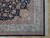 9' x 12'3" Indian wool rug corner showing sky blue border, rose stripes and ivory fringe