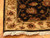 Corner detail showing ivory floral border, black outer binding and hand-tied cotton fringe ends