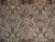 Close-up of wool pile showing burgundy palmettes, cream blossoms and green leaves on gray sage field