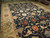 9'11" x 14'1" navy Oushak rug at an angle, rust palmettes and cream vines across indigo field