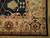 Corner close-up of ivory border rosettes, camel cartouche, rust blossoms and silky hand-spun wool pile
