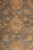 Detail of a gold palmette with grey center petals surrounded by ivory vine scroll and apricot blossoms
