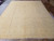 Overhead view of pale neutral beige Chobi rug on tile showroom floor showing full all-over pattern