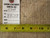 Back tag reading genuine hand woven Oriental rug beside tape measure against the knotted wool weave