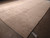9 by 12 beige Gabbeh rug seen from an angle with inventory tag on the floor