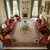 Formal living room styled with ivory Tabriz palace rug, rust velvet sofas and crystal chandelier