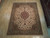 7'11 x 10'2 Persian Tabriz rug displayed on light hardwood floor showing full medallion layout