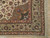 Corner detail showing brown spandrel, green floral border and ivory fringe on Tabriz rug