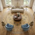 Round Chobi rug anchoring a cream sofa, blue armchairs and round wood coffee table in living room