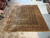 Large blue and rust Oriental rug laid out in Freeport showroom under warm overhead lighting