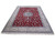 Angled display of red wool and silk Nain rug showing ivory border and blue medallion