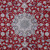 Close-up of navy and ivory star medallion with green center on deep red floral field