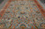 Angled floor view of the blue field with green, gold and rust serrated leaf motifs