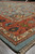 Low angle corner view of the 10x14 blue and coral Oriental rug with fringe
