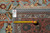 Back of the rug with hand woven tag, tape measure and visible knot rows