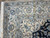 Corner detail of ivory main border with sky blue rosettes, palmettes and white cotton fringe