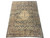 7'4" x 10' antique Tabriz Persian rug at an angle showing camel border and gold field