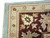 Corner detail showing cream guard borders, cotton fringe and burgundy border with ivory sunburst flowers