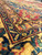 Corner border detail showing gold guard stripes, navy vinework and the crimson field beyond