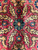 Macro of crimson field flowers with teal and green rosettes on soft lustrous wool
