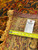 Back tag marked genuine hand woven Oriental rug next to a tape measure on the foundation
