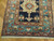 End panel detail showing sage medallion, chalky blue border and ivory fringe on wool pile