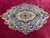 Overhead close-up of the navy medallion with pink roses, sky blue blossoms and gold arabesques