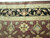 Border detail with ivory vinework on black, sage palmettes and rust field flowers in wool
